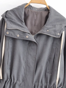 Detail of grey hooded windbreaker with metal zipper and cream drawstrings