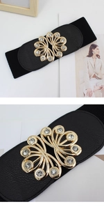 Detail of black elastic waist belt featuring a gold hollow floral buckle with rhinestones