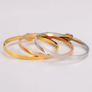 Detailed macro view of stacked stainless steel bangles in gold, rose gold and silver finish