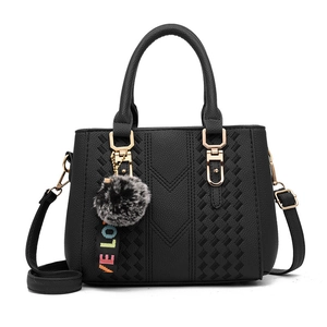Black pebbled leather tote bag with woven detail, gold hardware and plush pom-pom charm
