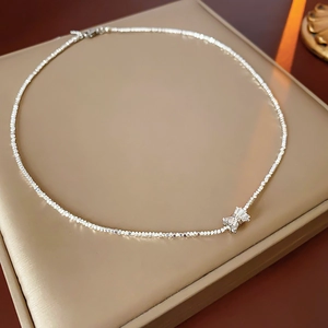Vue détaillée du collier à nœud argenté avec cristaux étincelants sur un présentoir