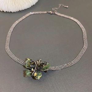 Green crystal butterfly pendant necklace with multi-strand woven chain and adjustable clasp