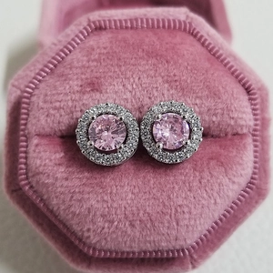 Macro shot of pink halo stud earrings with round zircon center in a pink velvet box