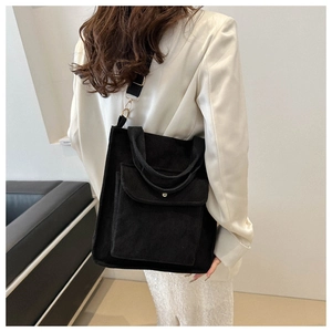 Detail of black corduroy tote bag with adjustable strap and golden metal hardware