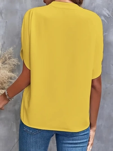 Back view detail of casual yellow V-neck shirt showing smooth fabric and loose summer fit