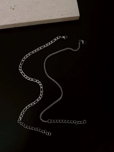 Detail of silver stainless steel Figaro and cable chain bracelets with lobster clasps