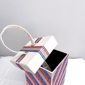 Macro detail of cube evening bag featuring luxury red and blue rhinestone stripes