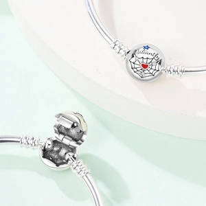 Detail of silver beaded bracelet featuring Valiantly engraving and heart charm detail