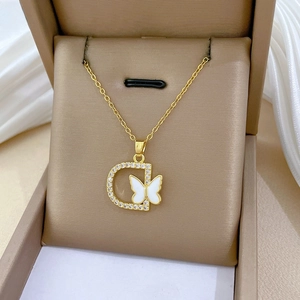 Detail of gold necklace with D-letter pendant, white butterfly and diamonds in a jewelry box