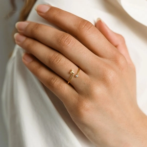 Adjustable gold zodiac letter A ring with small zircon stone shown on finger