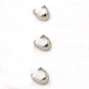 Macro detail of three silver stainless steel pinch bails for DIY jewelry making