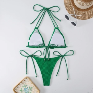 Flat lay of green checkered bikini with side-tie bottoms and summer beach accessories