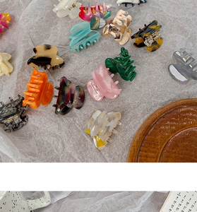 Macro shot of colorful acetate hair claw clips in various patterns on textured background