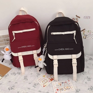 Detail of canvas school backpack with flip-top buckle and cute duck pendant accessory