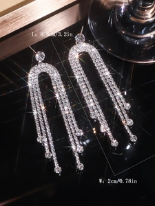 Macro shot showing dimensions of silver rhinestone tassel earrings at 8.5cm by 2cm size