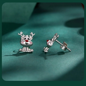 Macro shot of silver reindeer Christmas stud earrings with red and pink enamel details