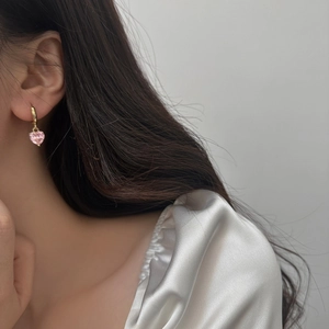 Close-up of a pink heart zircon pendant earring worn on a model for a sweet style