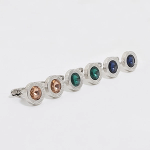 Détail de boutons de manchette de luxe avec cristaux champagne, émeraude et bleu