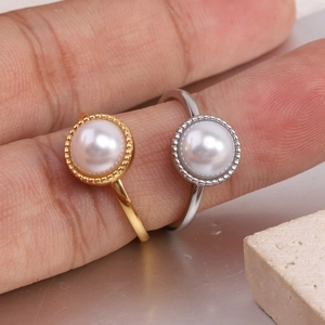 Detailed macro view of gold and silver steel rings with pearl inlay and milgrain edge