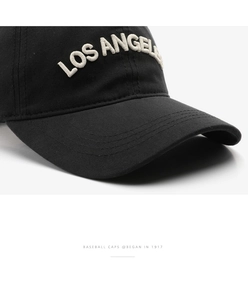 Detailed close-up of white 3D Los Angeles embroidery on black cotton baseball cap