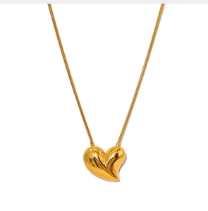 Macro shot of 3D heart pendant with sleek golden finish on a delicate snake chain