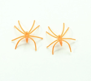 Macro shot of two small orange plastic Halloween spiders for spooky party decorations