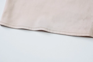 Dettaglio ravvicinato delle cuciture precise e dell'orlo liscio dell'elegante vestito