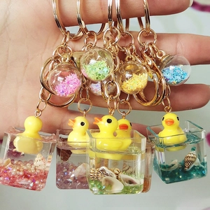 Close-up of floating duck charms with colorful liquid inside acrylic keychains