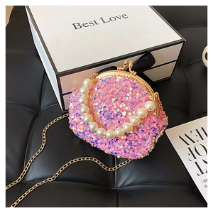 Pink sequin mini round shell bag with pearl handle and golden chain on black background