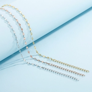 Glinsterende enkelbandjes in goud, zilver en roségoud op een blauwe achtergrond