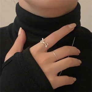 Detail of S925 sterling silver bow knot ring set worn on finger with minimalist style