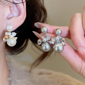 Vue macro détaillée de boucles d'oreilles grappe en perles plaquées or 14 carats