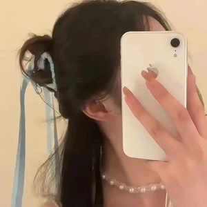 Dettaglio della molletta per capelli con nastro azzurro indossata lateralmente