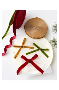 Detailed view of red, green, and yellow velvet ribbons and bows for Christmas DIY crafts
