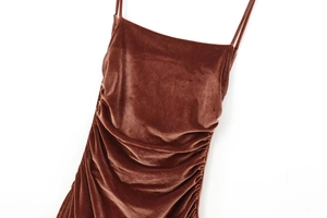Detail of caramel velvet midi dress showing side ruching texture and soft fabric sheen