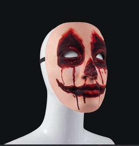 Close-up of Halloween horror clown mask with realistic red blood splatter and elastic band