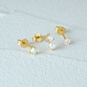 Detail of 925 sterling silver gold stud earrings set featuring opal, pearl and zircon