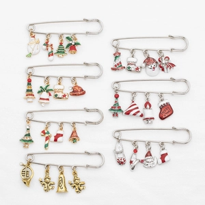 Detailed close-up of 7 enamel Christmas pins including Santa, bells and snowflake motifs