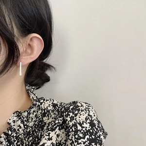 Close-up of minimalist S925 sterling silver rectangular bar earrings worn by a model