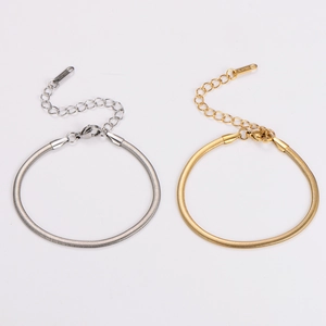 Detailed macro of gold and silver snake chain bracelets with lobster clasp and extension