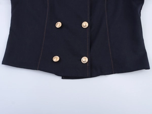 Detail of navy blue blazer with double-breasted gold buttons and orange contrast stitching