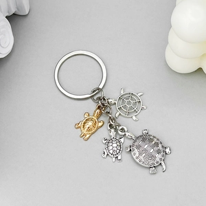 Detail of vintage silver turtle and helm charms on a decorative keychain accessory