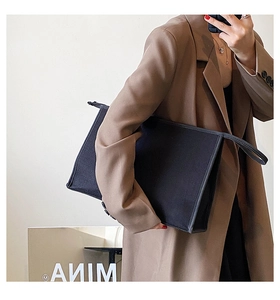 Grand sac à main business en toile noire, cabas spacieux présenté en style de vie