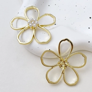 Detailed view of hollow gold flower earrings with pearls showing front and back structure