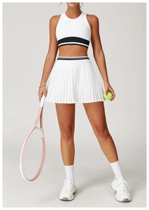 Detail of white pleated tennis skirt and crop top set with striped waist and pink racket