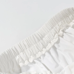 Détail de la taille élastique à volants sur un short de loisirs blanc en tissu lisse