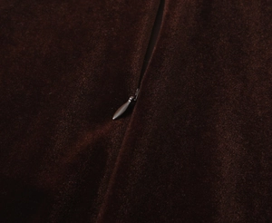 Détail macro d'une fermeture éclair invisible sur une robe en velours marron élégante