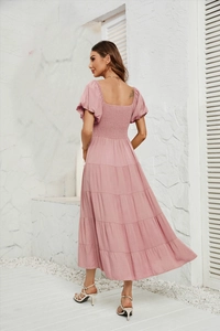 Détail de la robe rose à manches bouffantes avec dos nu carré et jupe à plusieurs niveaux