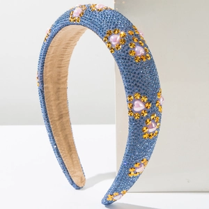 Macro shot of blue padded headband with rhinestones, gold stars and pink pearls