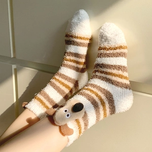 Detail of coral fleece socks with 3D puppy design and striped warm plush texture